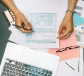 Mulher calculando o CMV (custo de mercadoria vendida)